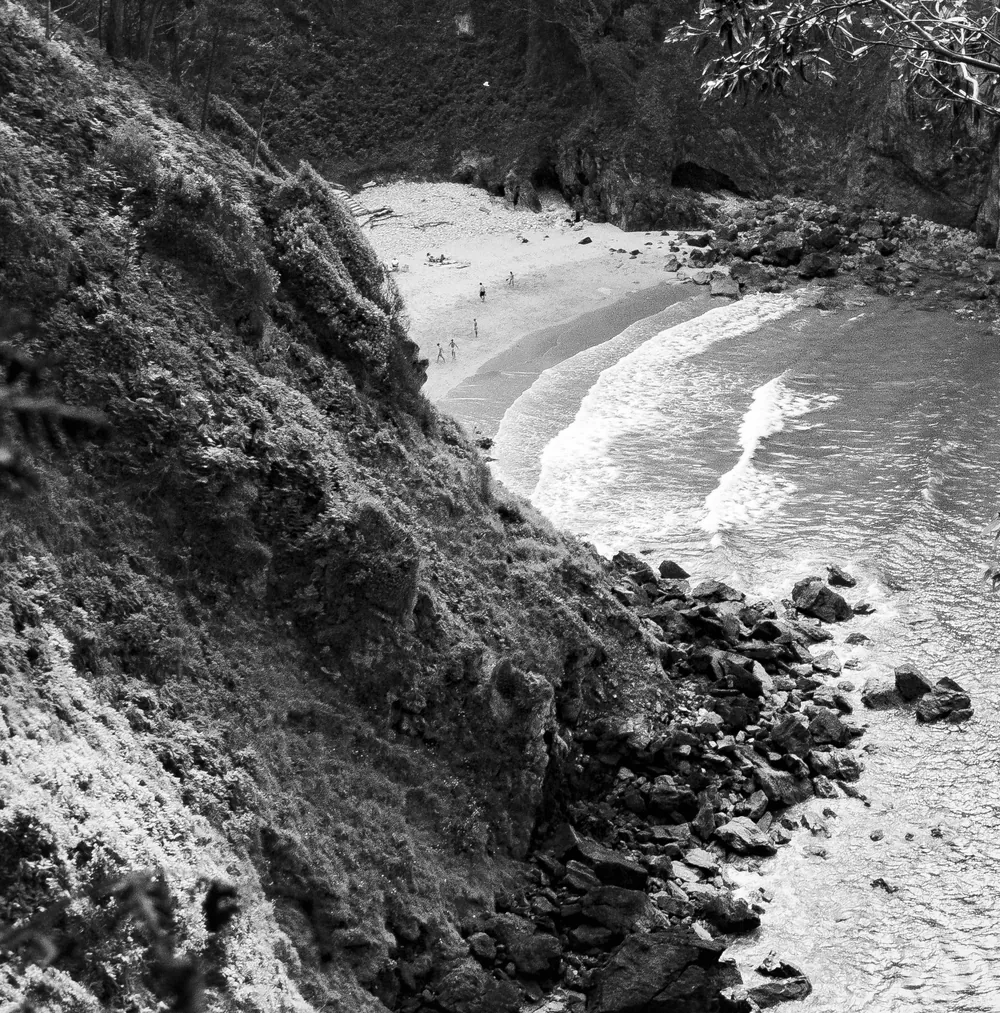 Cala recogida entre rocas, en blanco y negro