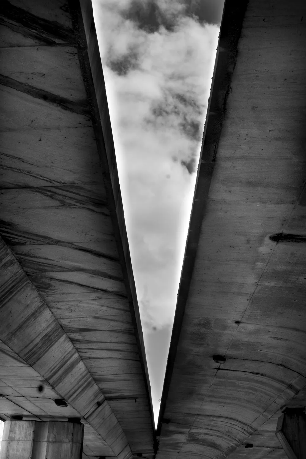 Vista desde debajo del tablero del puente: una cuña de cielo entre el hormigón