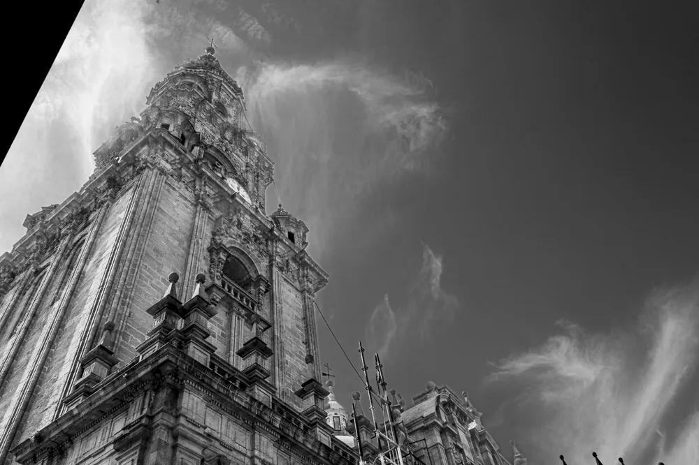 Torre de una catedral en contrapicado, con las nubes en movimiento